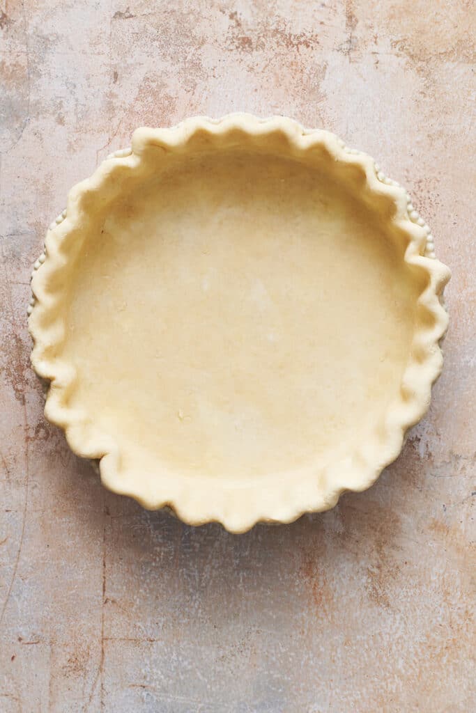 Press it into a pie dish, trim the edges, and crimp the rim