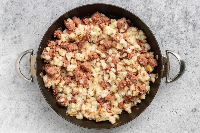 Remove the skillet from the heat and stir in the chopped corned beef along with the salt, distributing the meat evenly throughout the potato mixture