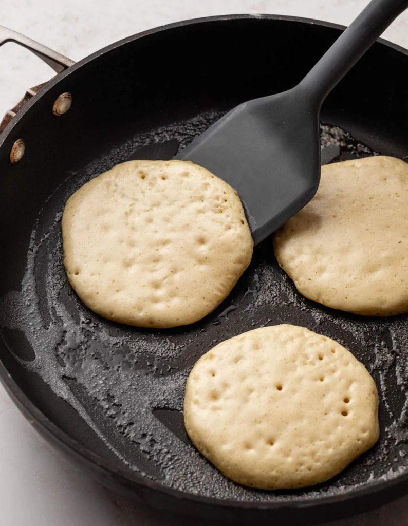 Scoop or pour a portion of batter onto the hot surface and cook until the edges look set and bubbles form on the surface