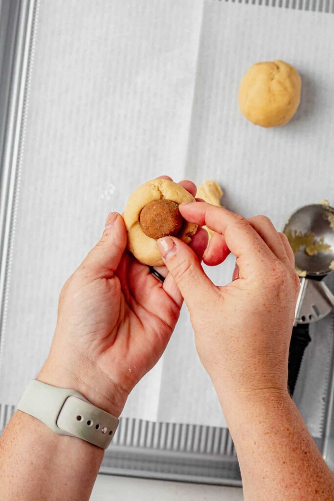 Scoop ¼ cup of chilled dough, split in half, create a well in one half, place filling inside, top with remaining dough, pinch seams, and roll into a ball