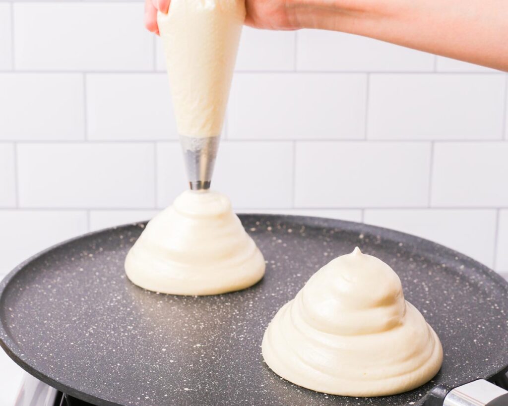Spoon or pipe the batter into tall mounds in the pan, keeping the shape as high as possible