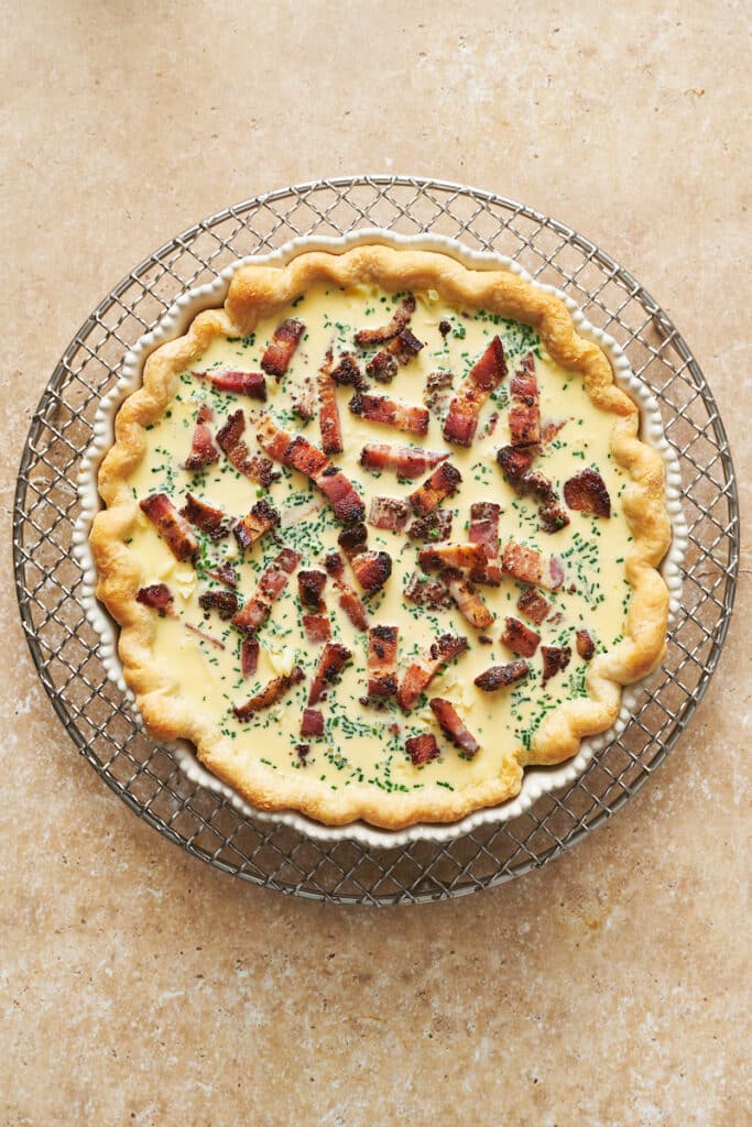 Spread the cooked onions over the baked crust, followed by half of the bacon and all of the cheese