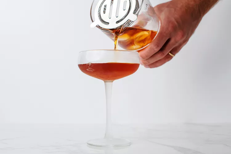 Strain the liquid into a pre-chilled cocktail glass to remove the ice