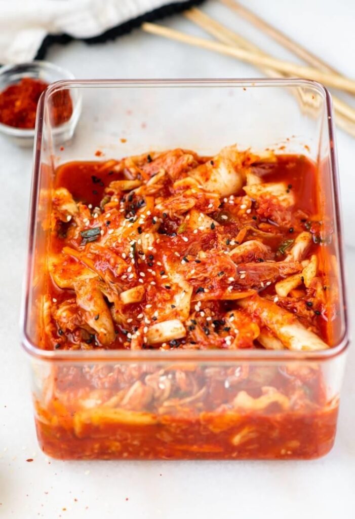 Transfer the coated kimchi into an airtight container, pressing it down firmly to remove air pockets
