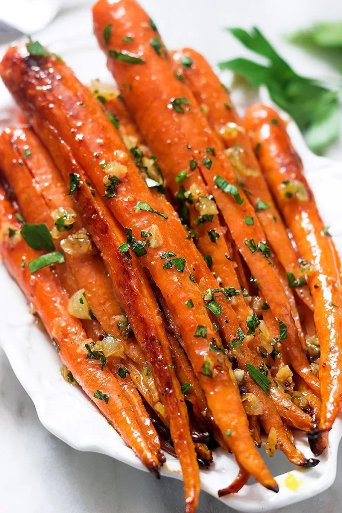 Transfer the roasted carrots to a serving dish, garnish with fresh parsley, and serve warm