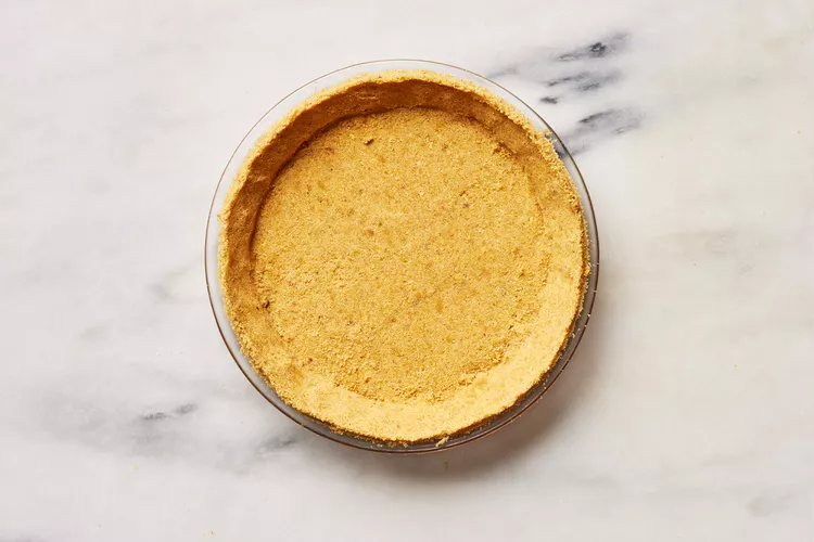Transfer the mixture into a 9-inch pie plate and press it firmly into the bottom and up the sides, making sure the layer is even and compact.