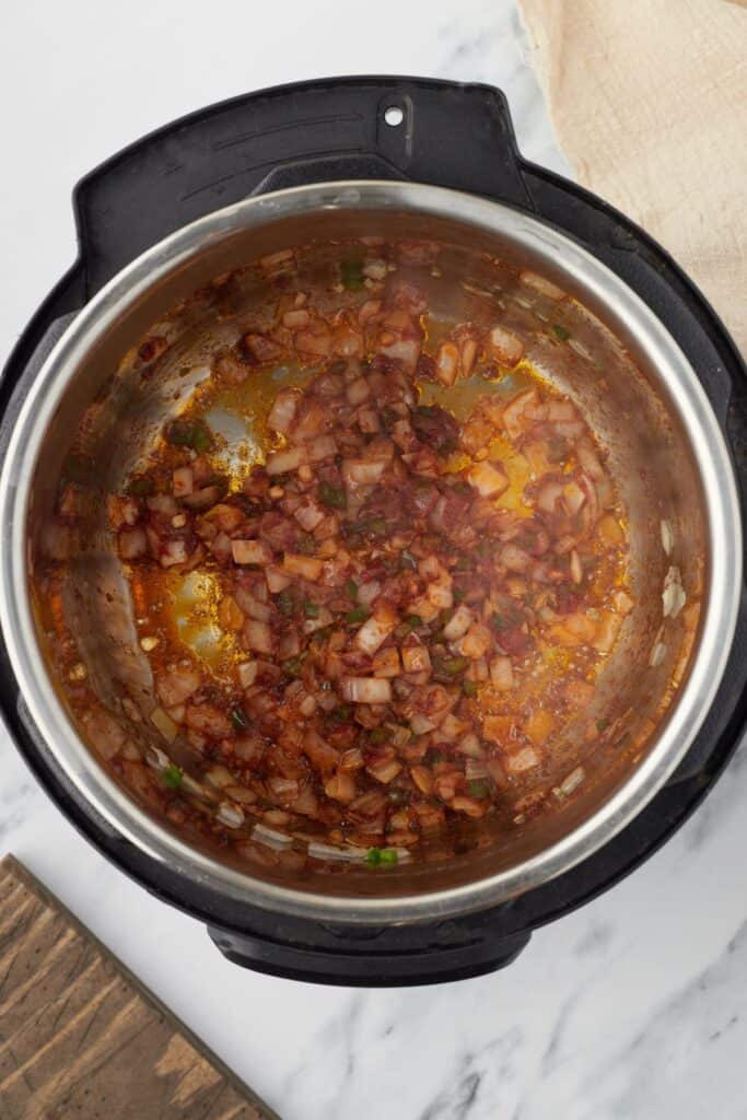 Add the tomato paste, chili powder, cumin, and salt, stirring constantly until the paste blends into the mixture and the spices become fragrant
