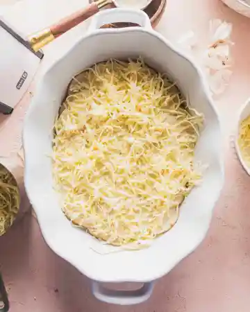 Continue layering the potatoes, sauce, and cheese until the dish is filled, finishing with a generous layer of cheese on top