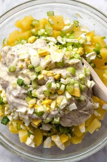 Fold the dressing into the potato mixture gently so the potatoes stay intact while everything becomes evenly coated