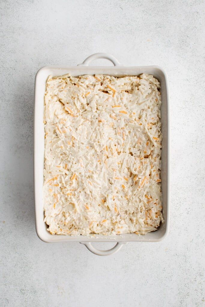 Gently fold in the thawed and drained hash browns, mixing just until everything is evenly coated without overworking the potatoes