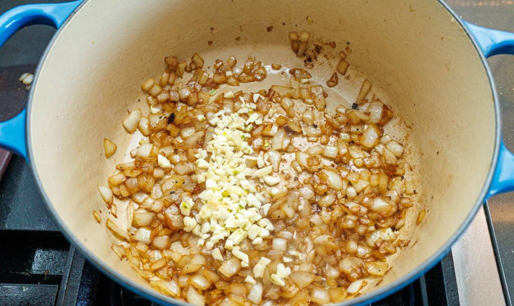 Reduce the heat and sauté the chopped onion until softened and lightly golden. Add garlic and cook briefly until fragrant, then stir in tomato paste and cook until slightly darkened.