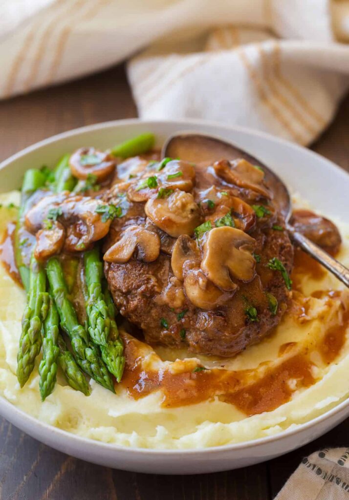 Return the cooked patties to the skillet and spoon the gravy over them. Let everything cook together briefly until the patties are heated through and coated in the rich sauce.