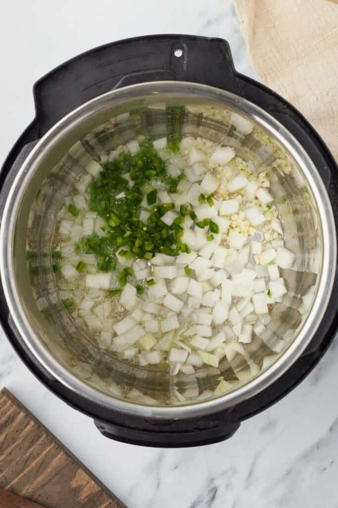 Set the Instant Pot to sauté mode and heat the avocado oil until it begins to shimmer, then add the garlic, jalapeño, and onion, cooking until the onion softens and turns translucent