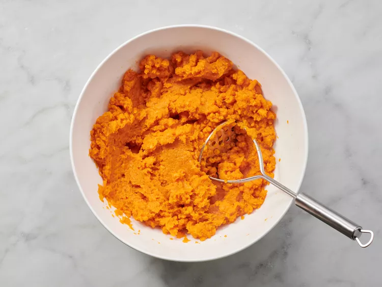 Transfer the cooked sweet potatoes to a large bowl and mash until smooth