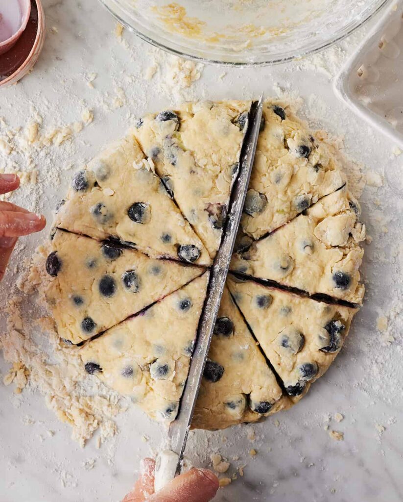 Transfer the dough onto a lightly floured surface and shape it into a round disk about one inch thick. Cut into eight equal wedges and place them onto the prepared baking sheet, leaving a bit of space between each piece.