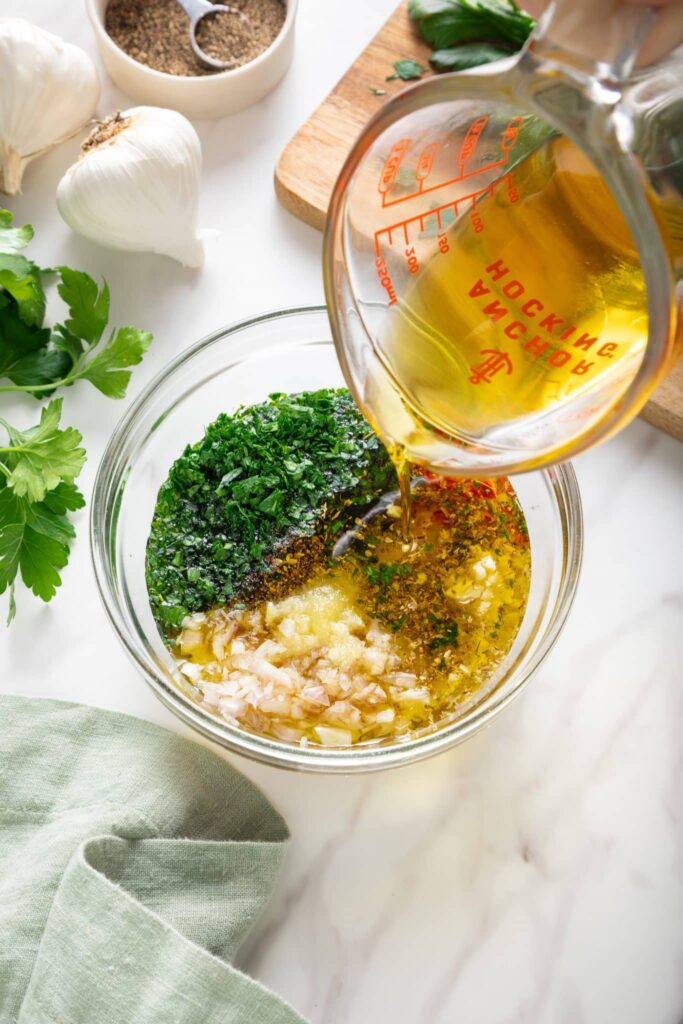 Pour in the olive oil and stir thoroughly until the mixture becomes glossy and well blended. The consistency should be loose enough to spoon easily.