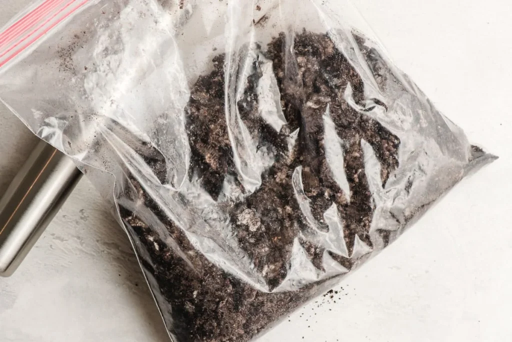 Place the Oreos in a large ziplock bag and crush them using a rolling pin until you have a mix of fine crumbs and small chunks. Add melted butter and mix well, then set aside.