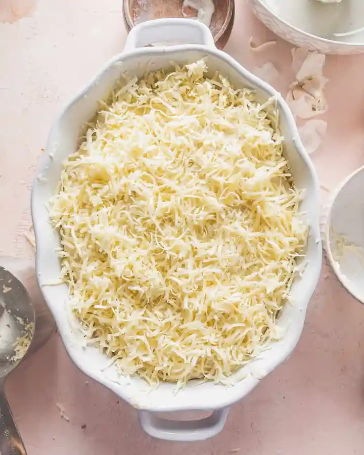Arrange a layer of thinly sliced potatoes in a baking dish, then spoon some of the cheese sauce over the top and sprinkle with a portion of the remaining cheese. Continue layering the potatoes, sauce, and cheese until the dish is filled, finishing with a generous layer of cheese on top.